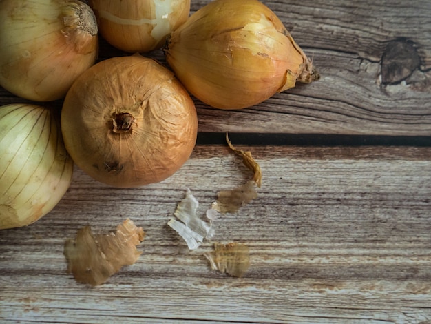 As cebolas na mesa de madeira para alimentos ou conceito de cozinha.