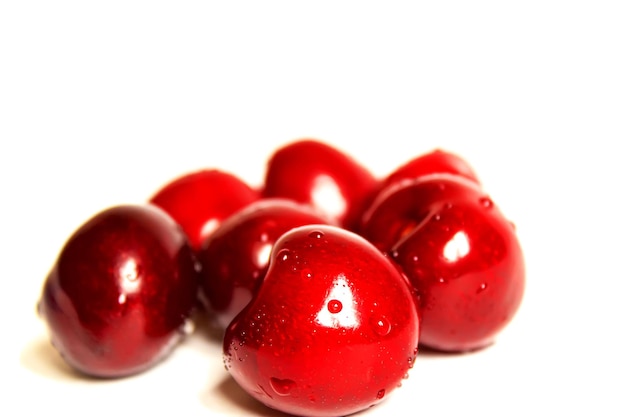 As cerejas isolam em um fundo branco. Foco seletivo. Natureza