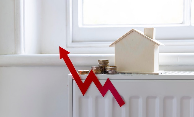 As contas de aquecimento doméstico aumentam Seta vermelha para cima com uma casa em um radiador de aquecimento