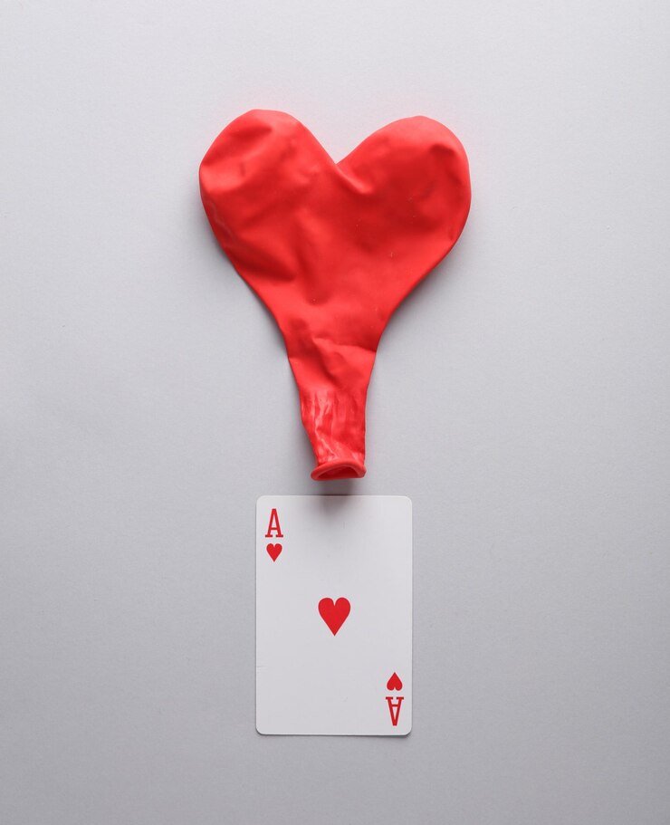 As de corazones con una bola en forma de corazón en un fondo gris Concepto de amor