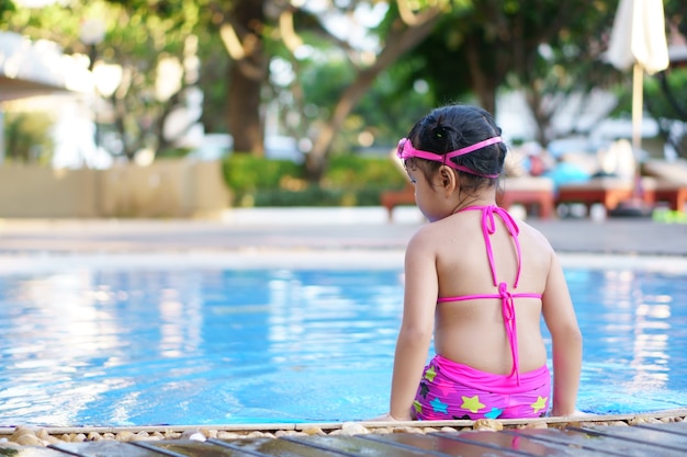 Foto as crianças asiáticas bonito desgaste biquíni sentar na piscina