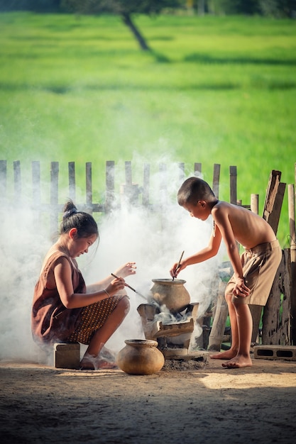 Foto as crianças asiáticas menino e menina estão cozinhando na cozinha