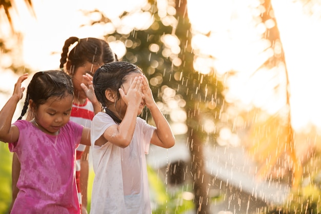 As crianças asiáticas se divertem com a água