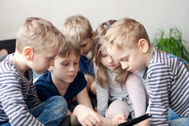 As crianças brincam no tablet