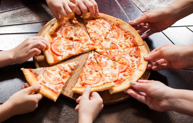 As crianças comem pizza em um restaurante.