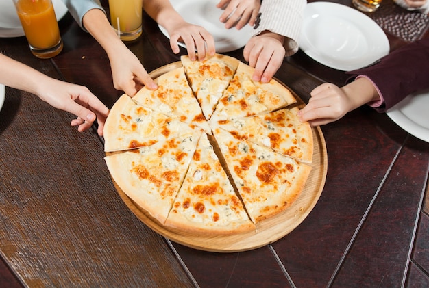 As crianças comem pizza em um restaurante.