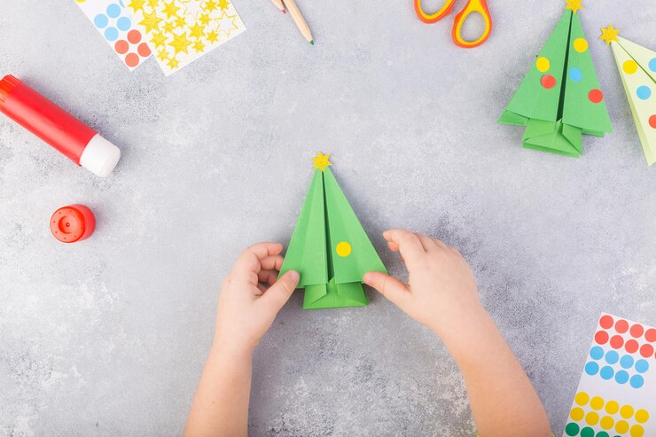As crianças decoram papel árvore origami Natal colagem de papel feito com as próprias mãos ...