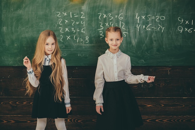 As crianças devem ser ensinadas a pensar, não o que pensar As crianças precisam de um treinador particular para acompanhar a classe Educação na escola primária aluno escrevendo no bloco de notas em sua mesa feliz