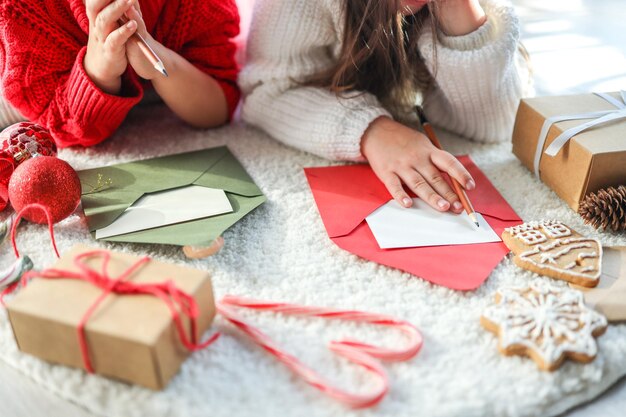 As crianças escrevem uma carta para a foto atmosférica festiva do Papai Noel