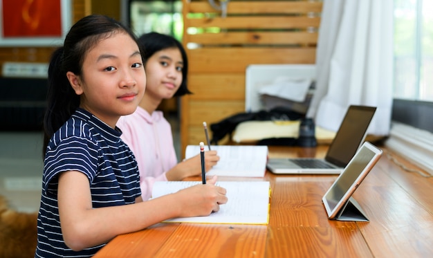 As crianças estão estudando com seus dispositivos eletrônicos