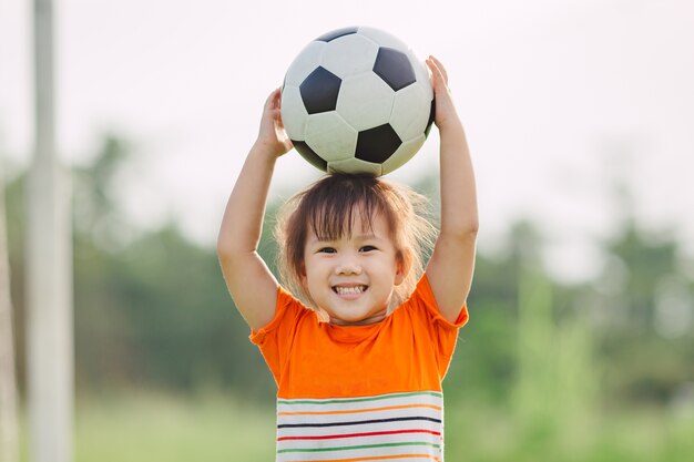 Foto as crianças estão jogando futebol para o exercício sob a luz do sol