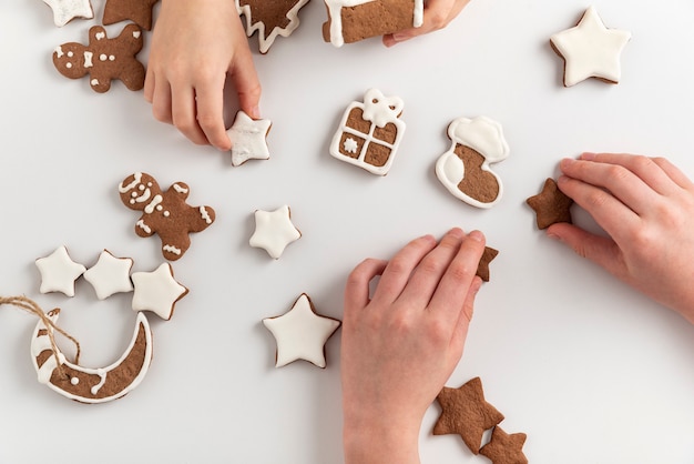 As crianças estão se preparando para o Natal. Biscoitos de gengibre nas mãos das crianças. Vista do topo.