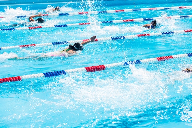 As crianças nadam na piscina ao ar livre durante o verão.