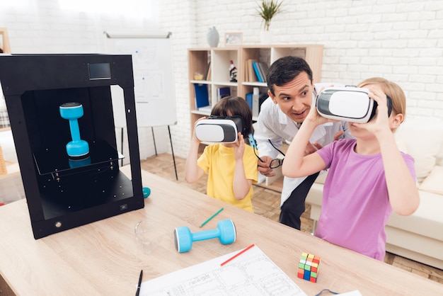 As crianças olham para os óculos de realidade virtual durante a aula.