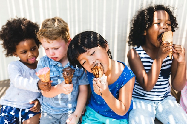 As crianças pequenas comendo sorvete gostoso