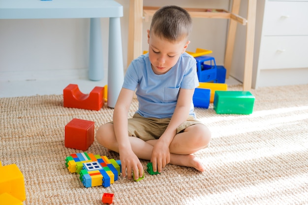 As crianças prées-escolar felizes jogam com blocos do brinquedo.