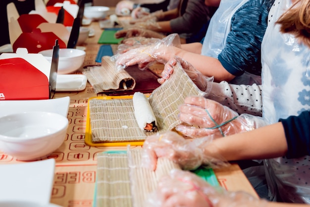 As crianças preparam sushi e pãezinhos. Restaurante de primeira classe.