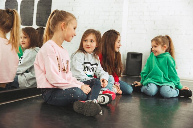 As crianças sentadas na escola de dança. Conceito de balé, hiphop, rua, funky e dançarinos modernos