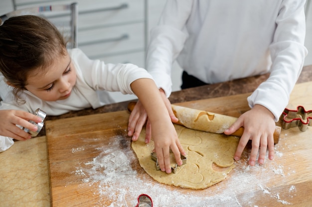 As crianças vão recortar os biscoitos de Natal com os formulários especiais