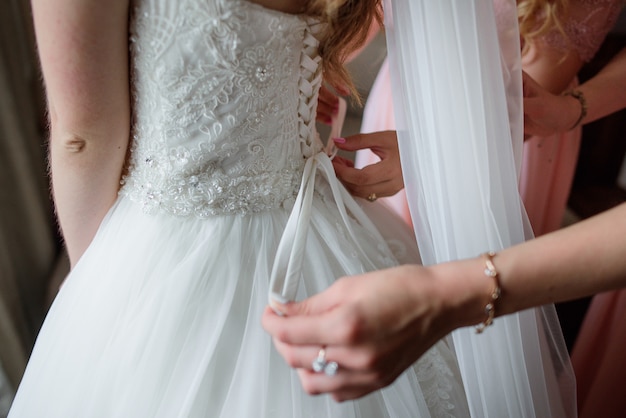 As damas de honra ajudam a noiva a se preparar para um casamento