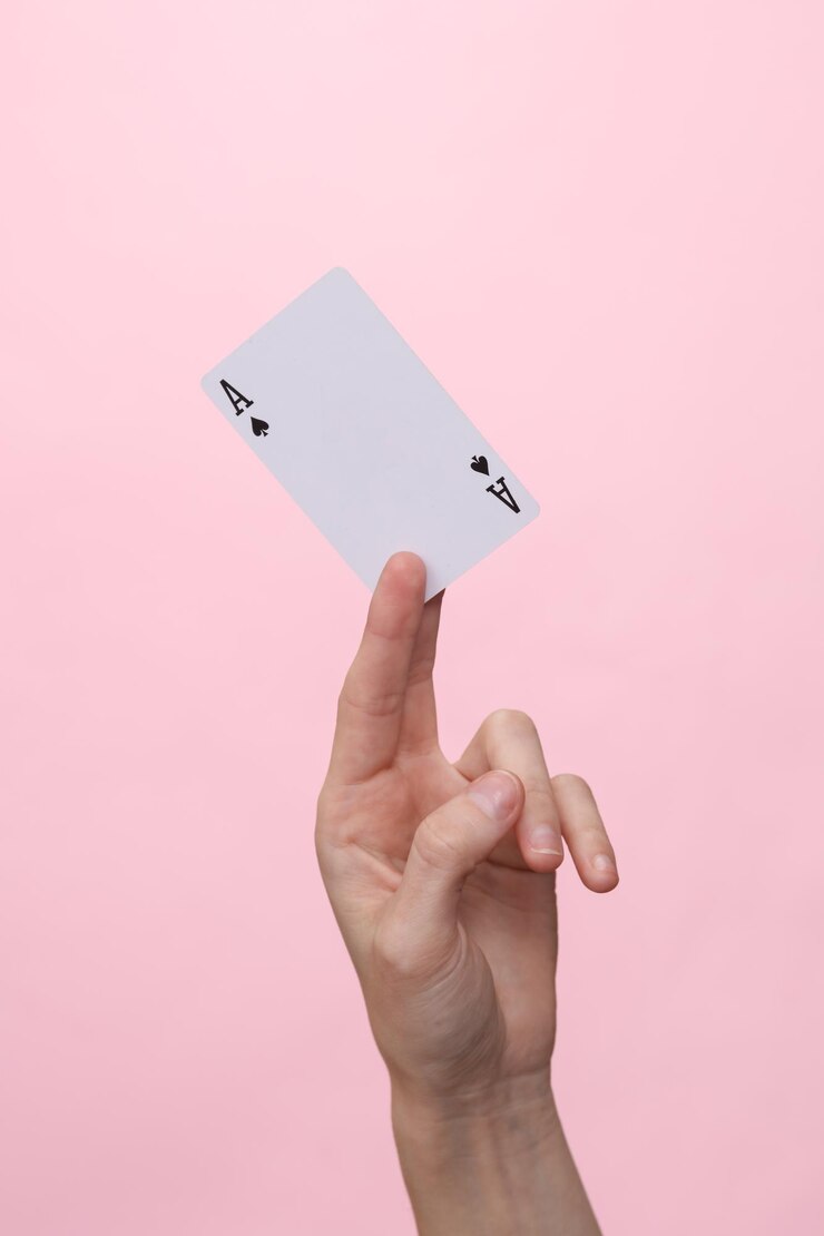 Foto ás de espadas em uma mão feminina em fundo rosa