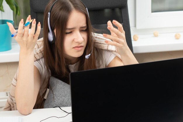 As dificuldades da educação online Webinar Aluno em casa com microfone nos fones de ouvido indignado na frente do monitor