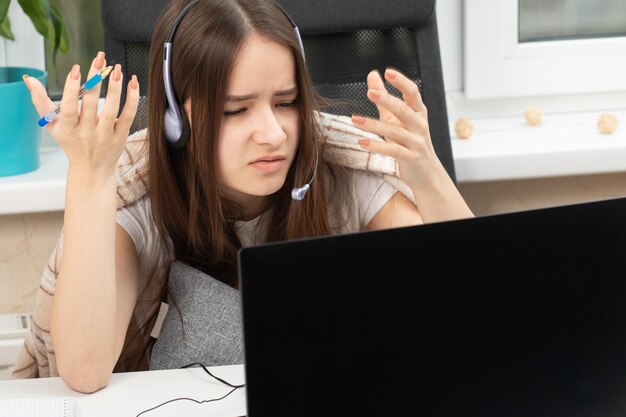 As dificuldades da educação online webinar aluno em casa com microfone nos fones de ouvido indignado na frente do monitor