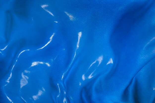 As dobras do tecido de seda azul esvoaçando ao vento