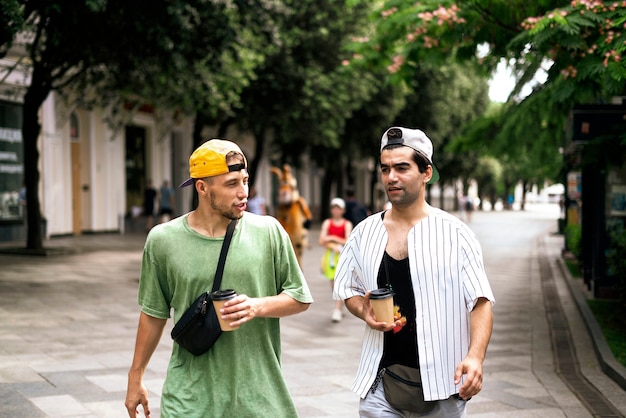 As duas pessoas caminham na rua e se falam, conversando