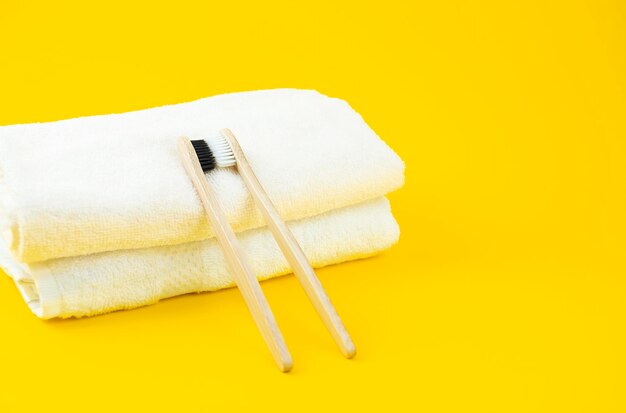 As escovas de dentes de material de bambu preto e branco estão em toalhas leves