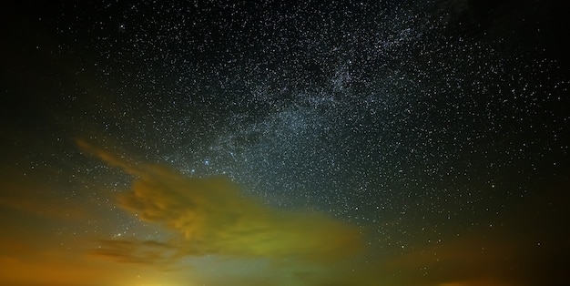 As estrelas da Via Láctea com nuvens no céu noturno