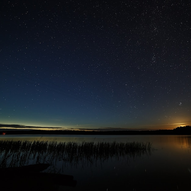 As estrelas no céu noturno sobre o rio