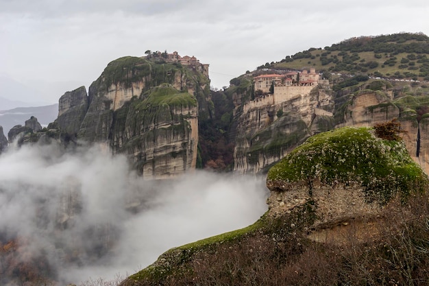 As falésias envoltas em nevoeiro em que os mosteiros de Meteora Tessália Grécia Trikala