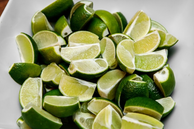 Foto as fatias de limão encontram-se em um prato branco. ingredientes para um coquetel.