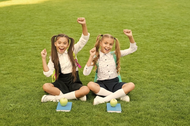As férias começaram Crianças felizes celebram feriados ao ar livre Meninas sentadas na grama verde Férias escolares Férias de verão e férias Lazer e tempo livre A escola está fora