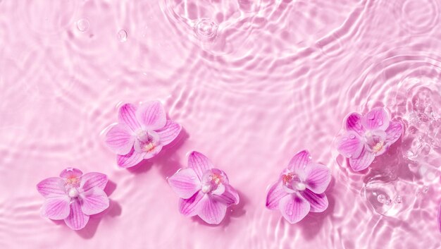 Foto as flores de orquídeas são manchas flutuantes de uma gota na água