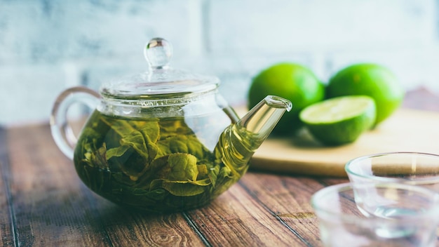 As folhas de chá são preparadas em água fervente e infundidas em um pequeno bule O conceito da festa do chá Chá verde em um bule