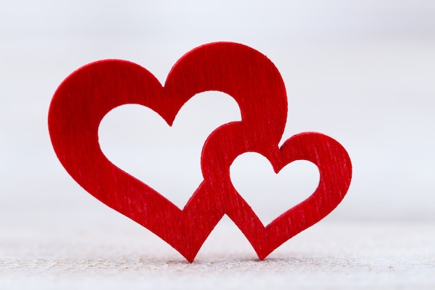 As formas de coração vermelho sobre fundo claro abstrato no conceito de amor para o dia dos namorados