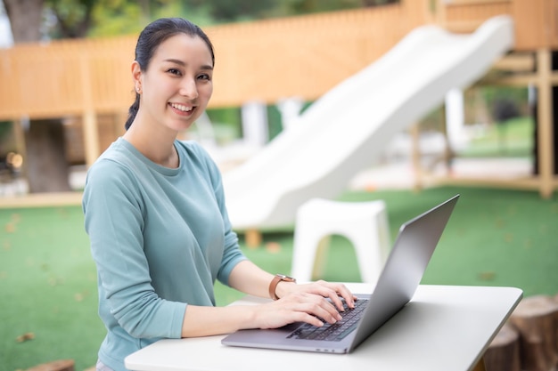 As funcionárias asiáticas usam laptops para reuniões digitais de cursos on-line, aulas de aperfeiçoamento de habilidades
