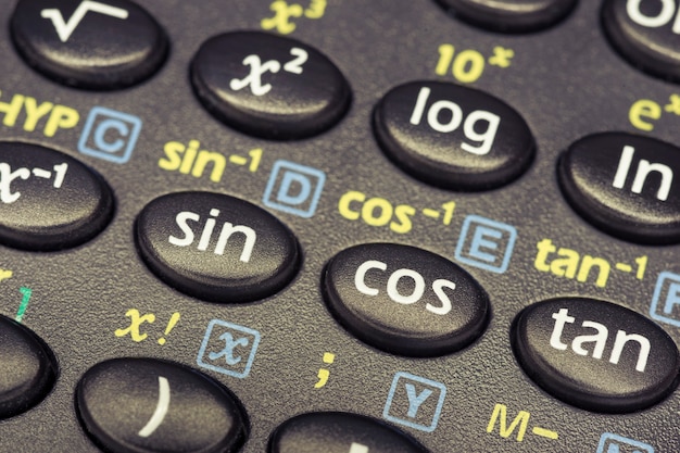Foto as funções de trigonometria pressionam os botões da calculadora científica com foco no botão cos