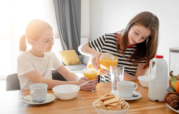 As irmãs das meninas comem saboroso café da manhã juntas