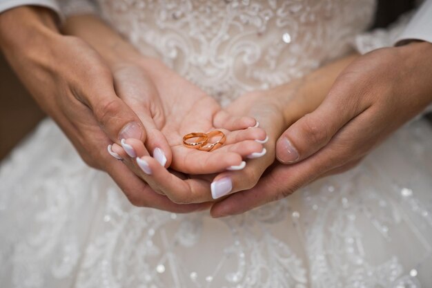 Foto as lindas mãos dos noivos se abraçam segurando o casamento