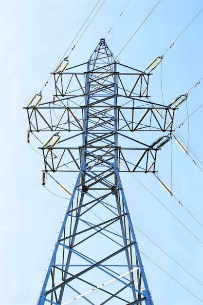 As linhas elétricas elevam-se sobre o céu azul claro