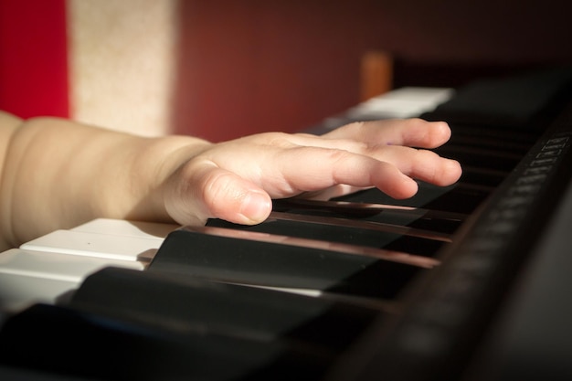 As mãos da criança no piano.