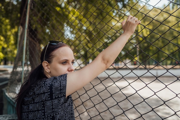 As mãos da mulher estão segurando as barras As mãos na treliça simbolizam a limitação em algo A mulher puxa as mãos pelas barras para o sol Conceito de liberdade feminina