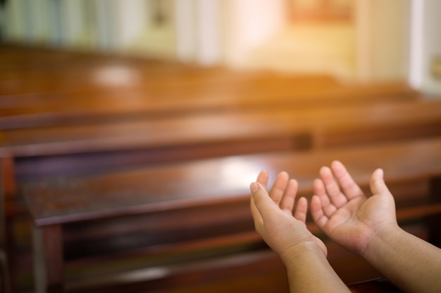 As mãos da mulher são adoração a deus cristão enquanto estão na igreja