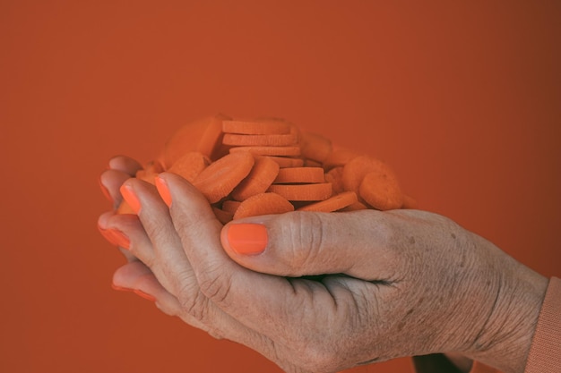 As mãos da mulher seguram cenouras cruas fatiadas prontas para cozinhar Dieta saudável vegetal vegetariano vegan