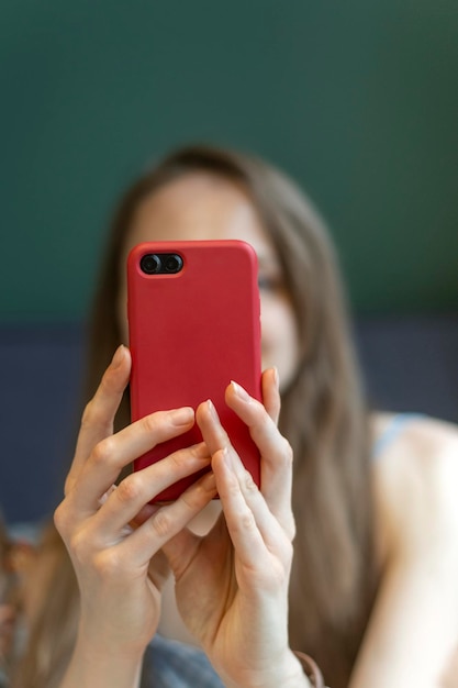 As mãos das mulheres seguram o smartphone garota tira selfie ou conversa com alguém em videochamada no café quadro vertical