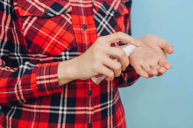 Foto as mãos das mulheres usam um desinfetante para limpar as mãos dos germes. regra de higiene na epidemia covid-2019. desinfecção das mãos com um desinfetante em aerossol. pandemia de coronavírus.