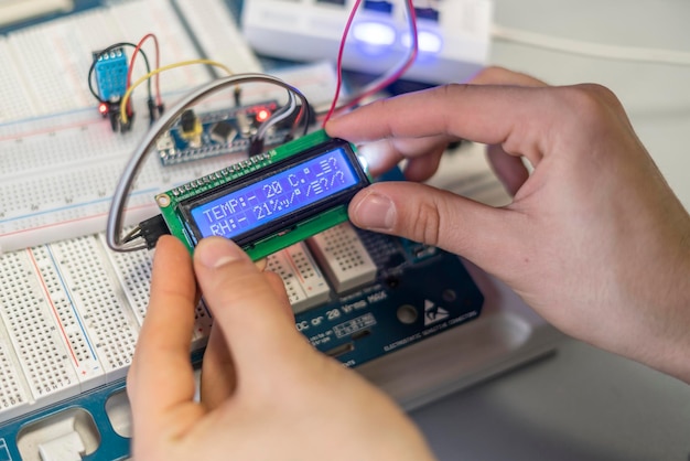 As mãos das pessoas conectam ou instalam chip de silício elétrico ou sensor b